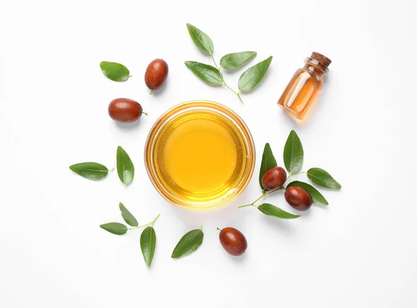 Bowl with jojoba oil and seeds on white background, top view — Stock Photo, Image