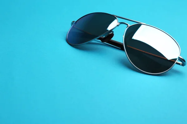 Κομψά γυαλιά ηλίου σε μπλε φόντο, χώρος για κείμενο. Μοντέρνο αξεσουάρ — Φωτογραφία Αρχείου