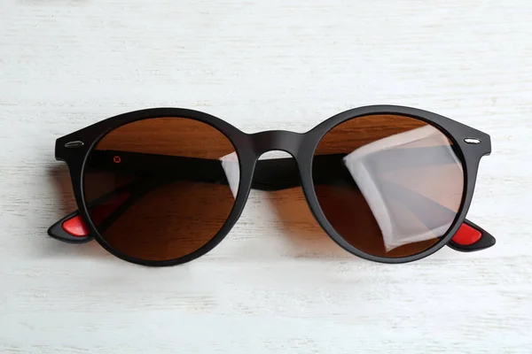 Snygga solglasögon på vit trä bakgrund, ovanifrån. Fashionabla tillbehör — Stockfoto