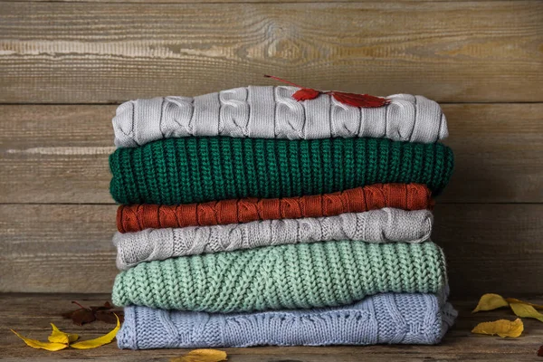 Stos swetrów na drewnianym tle. Jesienne ubrania — Zdjęcie stockowe