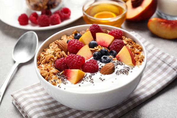 味道鲜美的自制麦片加酸奶放在灰色桌子上. 健康早餐 — 图库照片