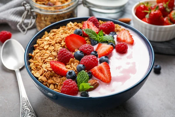 Smaklig hemlagad granola med yoghurt på grått bord, närbild. Sund frukost — Stockfoto