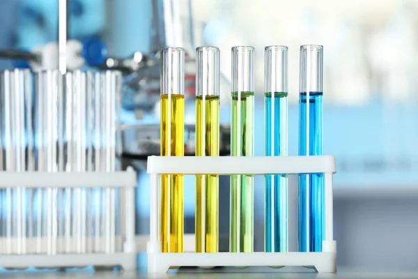 Laboratóriumi tesztcsövek színes folyadékokkal az asztalon — Stock Fotó
