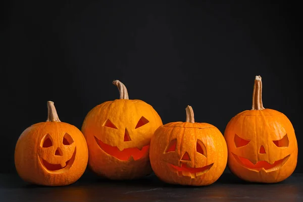 Abóboras com rostos assustadores no fundo preto. Tráfico de Halloween — Fotografia de Stock