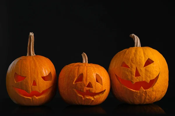 Abóboras com rostos assustadores no fundo preto. Tráfico de Halloween — Fotografia de Stock