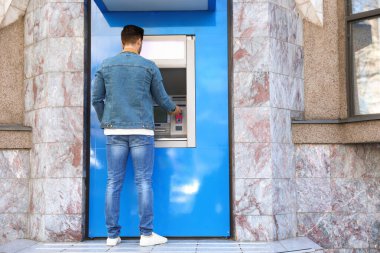 Modern nakit makinesini açık havada kullanan genç adam