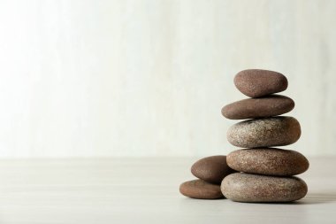 Beyaz arka plana karşı masaya spa taşları yığını, metin için alan