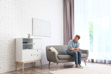 Genç adam soğuktan evde acı. Klima arıza