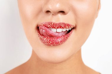 Beyaz arka planda şeker dudaklı genç kadın, yakın plan.