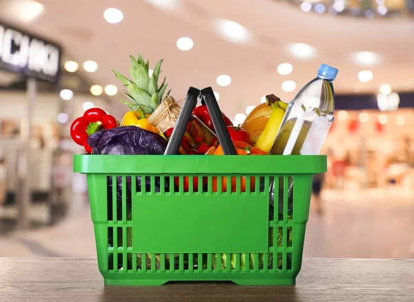 Panier avec produits d'épicerie sur la table dans un supermarché — Photo