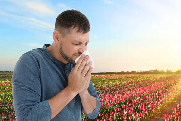 Pria yang menderita alergi dan mekar di latar belakang — Stok Foto