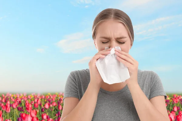 Giovane donna che soffre di allergia e campo fioritura su sfondo — Foto Stock