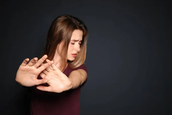 Молода жінка робить стоп- жест на темному тлі, зосередьтеся на руці. Простір для тексту — стокове фото