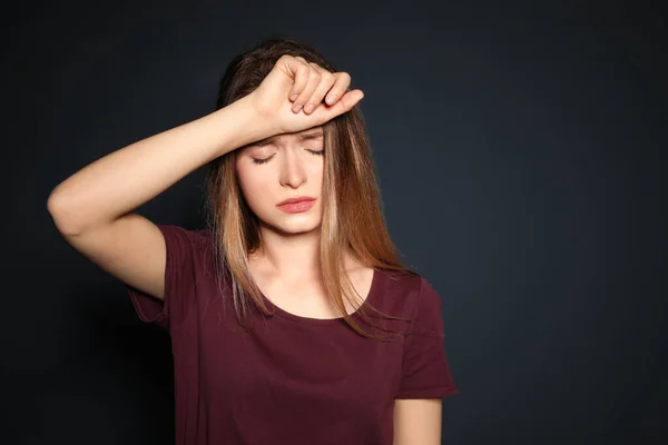 Porträt einer aufgebrachten jungen Frau auf dunklem Hintergrund. Raum für Text — Stockfoto