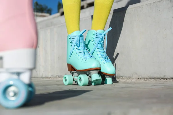 Jeune femme avec des patins à roulettes rétro en ville le jour ensoleillé, gros plan — Photo