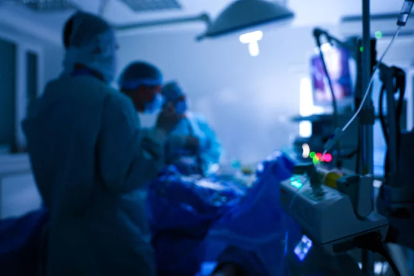 Vista offuscata del team medico che esegue un intervento chirurgico in sala operatoria — Foto Stock