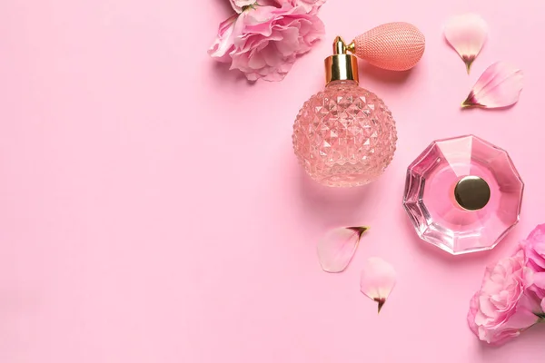 Flache Lagekomposition mit Parfümflaschen und Blumen auf hellrosa Hintergrund, Platz für Text — Stockfoto