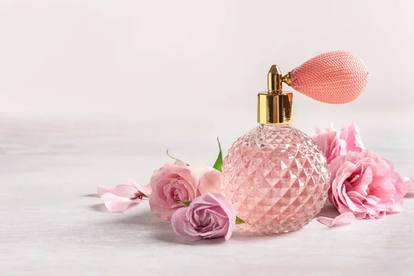 Vintage butelka perfum i kwiatów na jasnym tle, miejsce na tekst — Zdjęcie stockowe