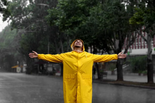 幸せな若いです男で明るいコート屋外で雨の日 — ストック写真
