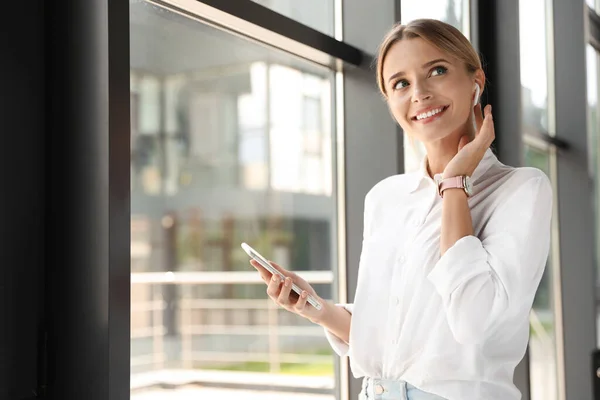 Portrait of female business trainer with smartphone indoors