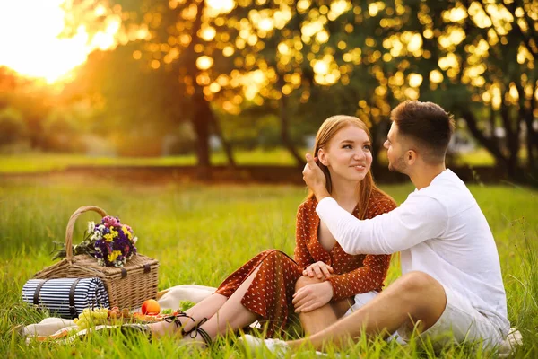 Gelukkige jonge paar met picknick in park — Stockfoto