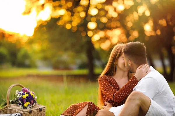 Glückliches junges Paar küsst sich im Park. Picknicksaison — Stockfoto