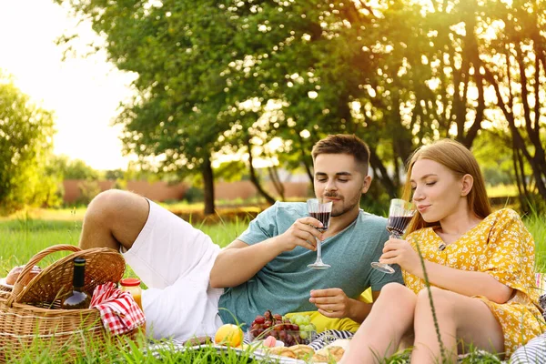 Gelukkig jong stel met glazen wijn picknicken buiten — Stockfoto