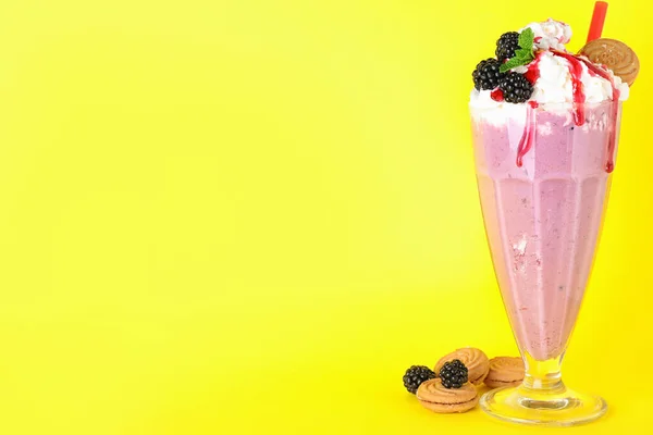 Savoureux milk-shake en verre, mûres et biscuits sur fond jaune. Espace pour le texte — Photo