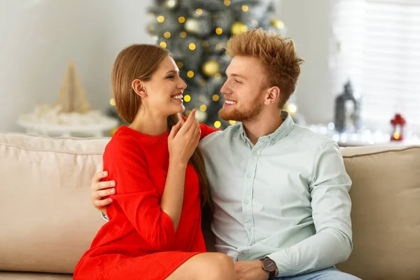 自宅のソファで幸せな若いカップル。クリスマスのお祝い — ストック写真
