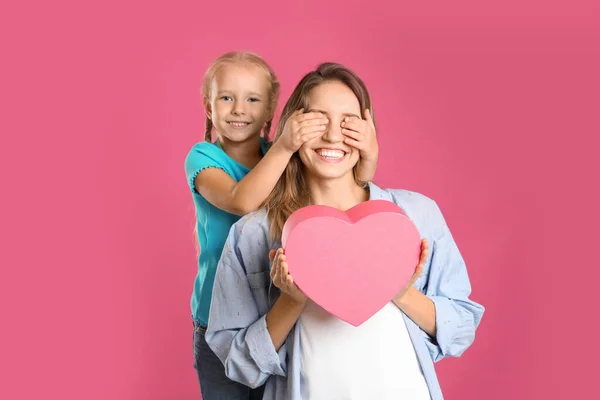 Petite fille félicitant sa mère sur fond rose. Joyeuse fête des mères — Photo