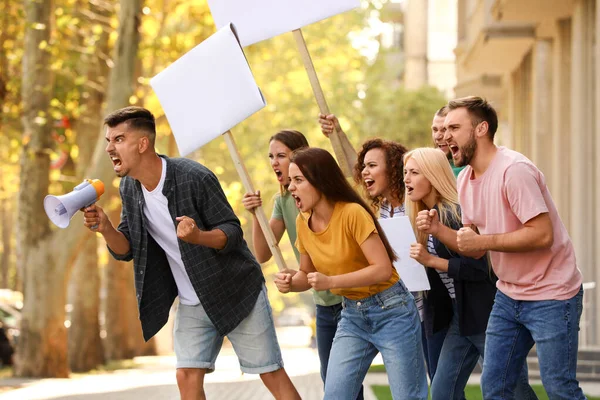 Arg ung man med megafon ledande protest utomhus — Stockfoto