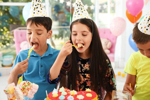 誕生日パーティーでおいしいケーキを食べる幸せな子供たち屋内 — ストック写真