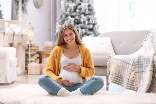若いです妊娠中の女性のために飾られた部屋で床に座ってクリスマス — ストック写真
