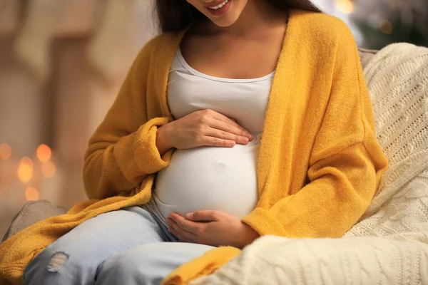Glad gravid kvinna i fåtölj på rummet inrett till jul, närbild. Väntat barn — Stockfoto