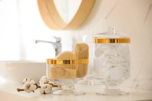 Vasi con batuffoli di cotone e spugne di spugna sul piano di lavoro in bagno — Foto Stock