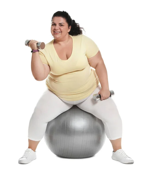 Mujer con sobrepeso haciendo ejercicio en la bola en forma con pesas sobre fondo blanco — Foto de Stock