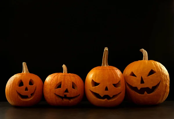 Assustador Jack abóbora cabeça lanternas na mesa cinza contra fundo preto, espaço para texto. Halloween decoração — Fotografia de Stock