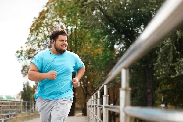 Jovem homem com excesso de peso correndo ao ar livre. Estilo de vida fitness — Fotografia de Stock