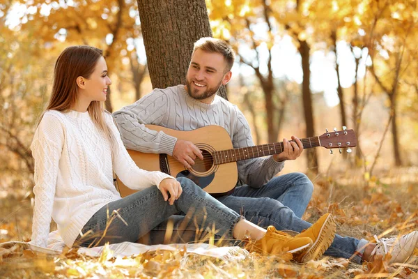 Jeune couple avec guitare dans le parc d'automne — Photo