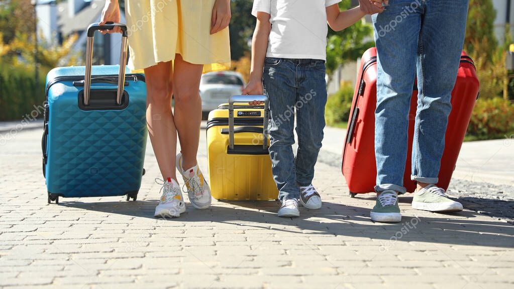 Family with suitcases walking outdoors. Moving day