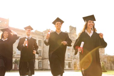 Açık havada diplomalı mutlu öğrenciler. Mezuniyet töreni