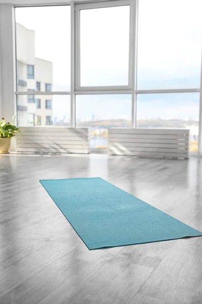 Unrolled light blue yoga mat on floor in room — Stock Photo, Image