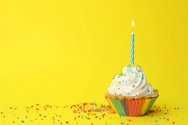 Magdalena de cumpleaños con vela sobre fondo amarillo, espacio para texto. Tarjeta de felicitación — Foto de Stock