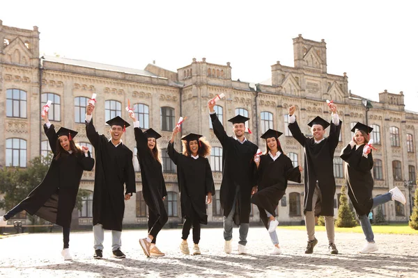 Ευτυχισμένοι φοιτητές με πτυχία στην ύπαιθρο. Τελετή αποφοίτησης — Φωτογραφία Αρχείου