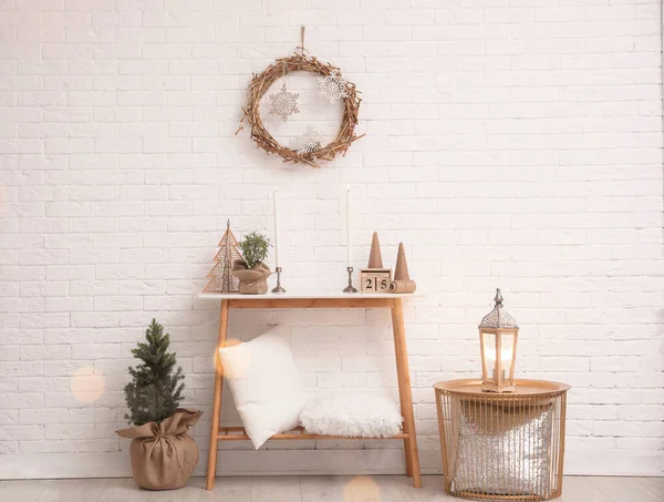 Mesa de consola con decoración de Navidad cerca de la pared de ladrillo. Idea para interior festivo —  Fotos de Stock