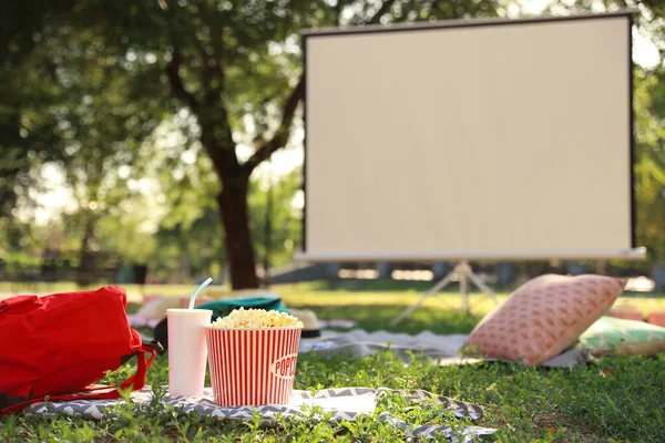 Popcorn i pić na zielonej trawie w kinie na otwartym powietrzu. Miejsce na tekst — Zdjęcie stockowe