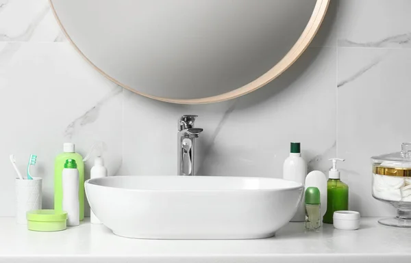 Roll-on deodorant and different toiletry on table in bathroom — Stock Photo, Image