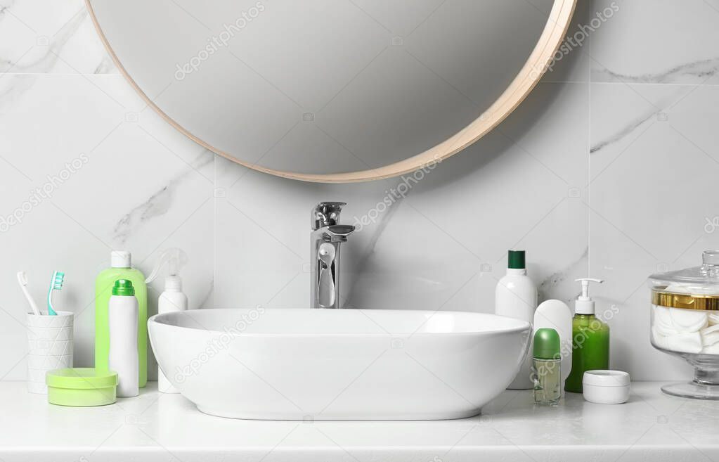 Roll-on deodorant and different toiletry on table in bathroom