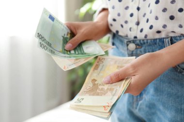 Odasında Euro banknotları olan bir kadın, yakın plan.