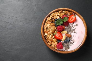 Sağlıklı ev yapımı granola, koyu gri masada yoğurt, üst manzara. Metin için boşluk